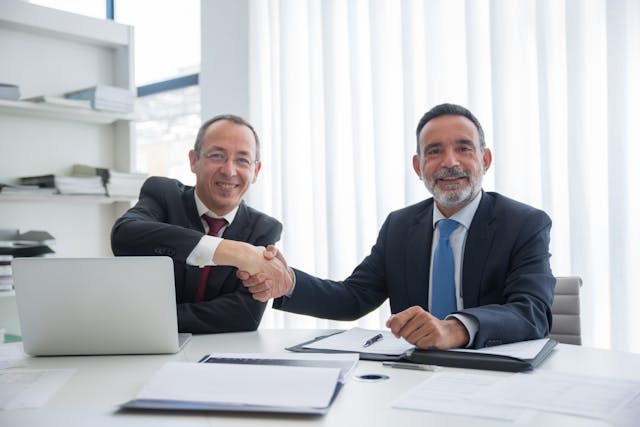 two business partners shaking hands after getting Criss-Cross Insurance (Guaranteed Funding), deal done by ontariobusinessprotection.com