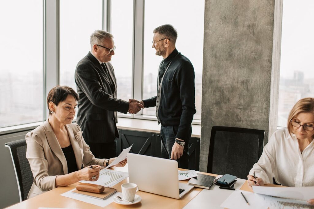 Small business owner shaking hands with insurance advisor. Happy about Immediate Financing Arrangement for business owners